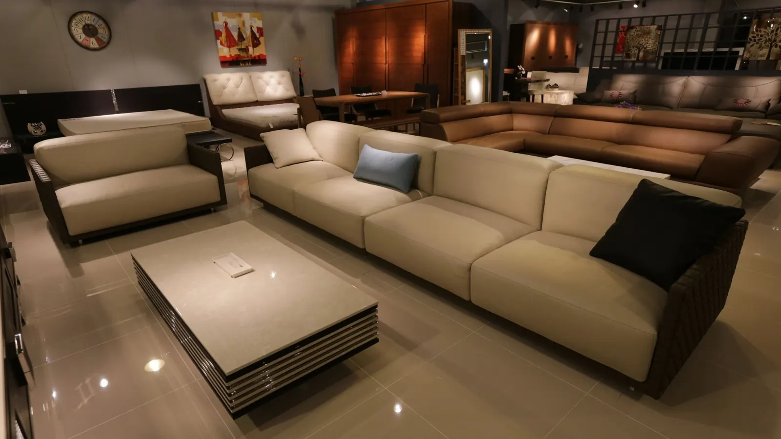 A furniture showroom with a beige sectional sofa and coffee table